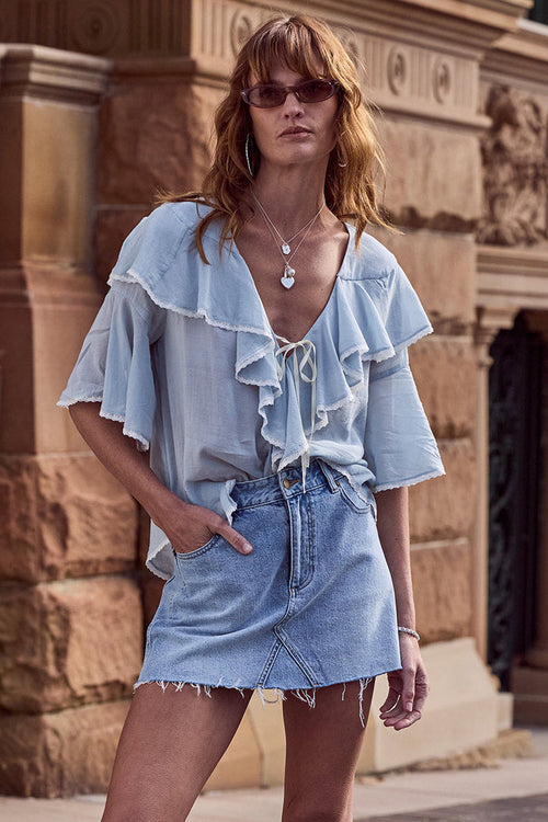 Spell women's 1979 Denim Mini Skirt in Vintage Blue organic cotton with frayed hem, worn by a model