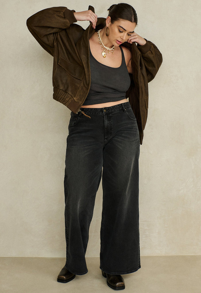 Vintage black organic cotton relaxed jeans, flat lay showing front view with 5-pocket design and custom Spell trims