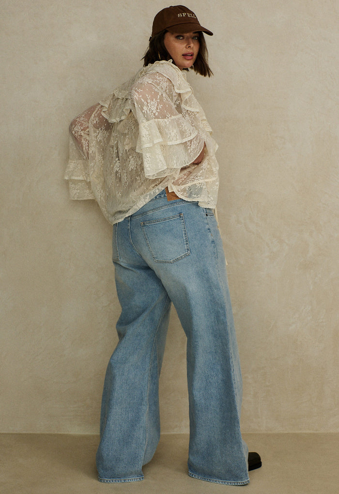 Back view of a model wearing vintage blue organic cotton wide-leg jeans with classic 5-pocket design and relaxed fit