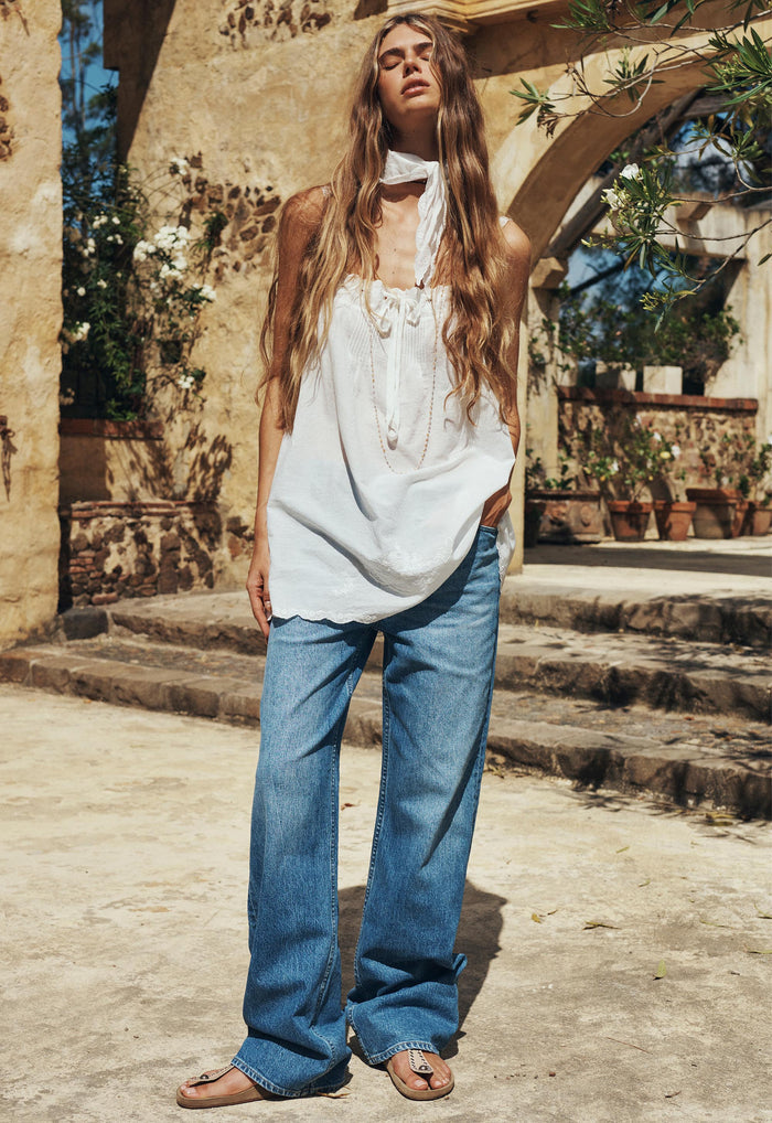 Model wearing washed indigo baggy jeans front view, mid-rise relaxed leg with wide-leg silhouette and front pockets