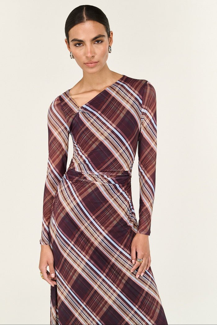 Woman wearing a plaid dress with long sleeves on a white background