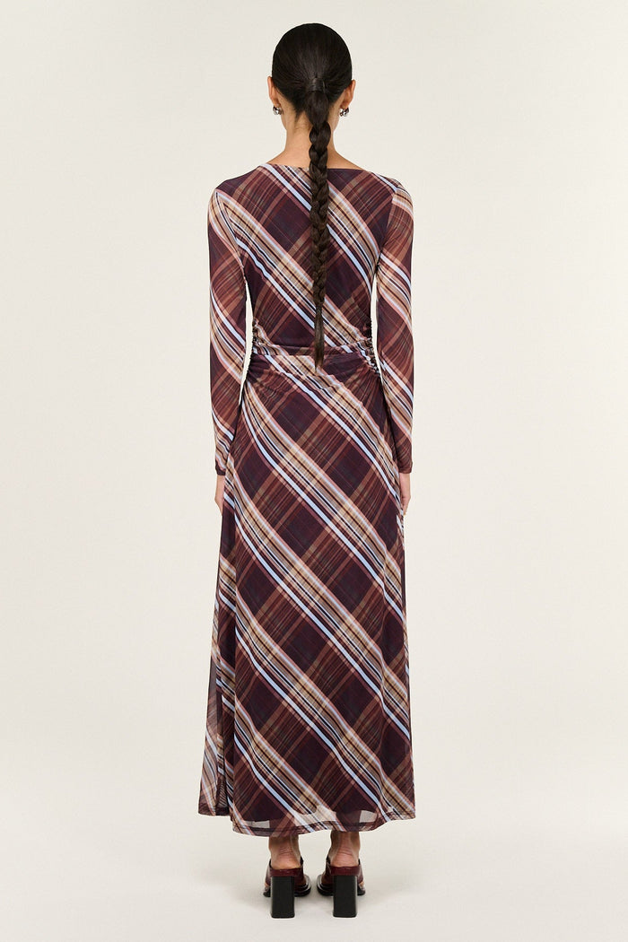 Woman wearing a plaid dress with a white background