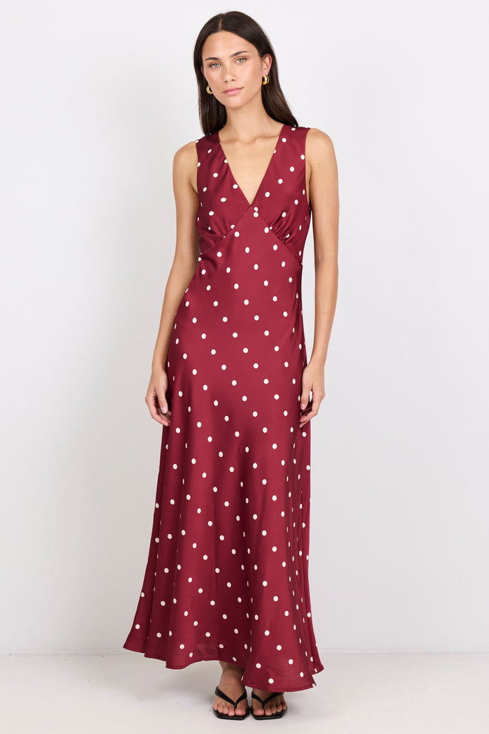 Woman wearing a burgundy dress with white polka dots on a white background
col_pattern