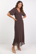 Woman wearing a brown dress with white polka dots on a white background