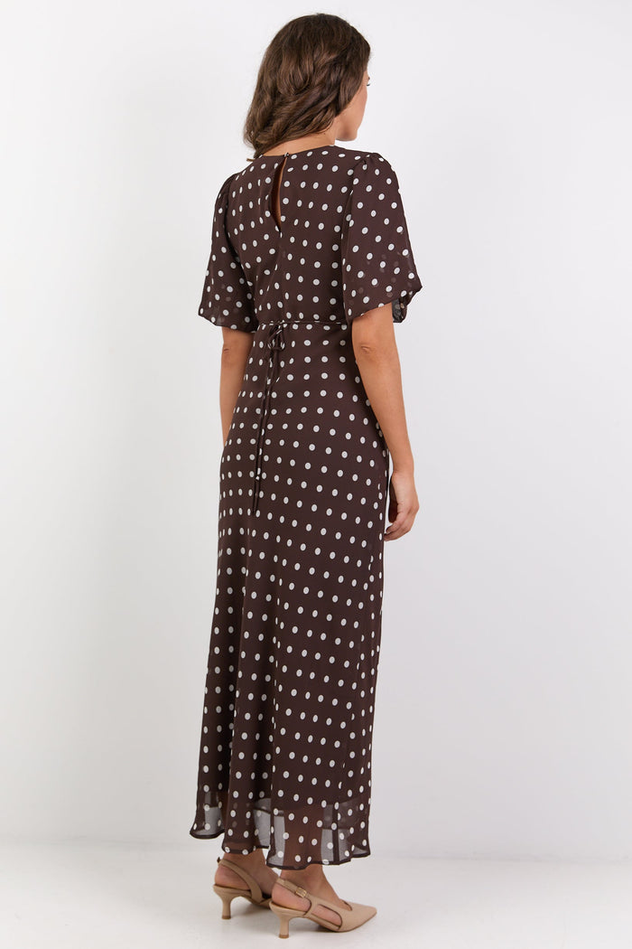 Woman wearing a brown polka dot dress on a white background