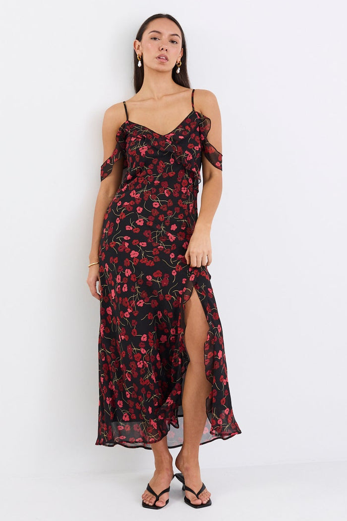 Woman wearing a floral dress standing against a white background