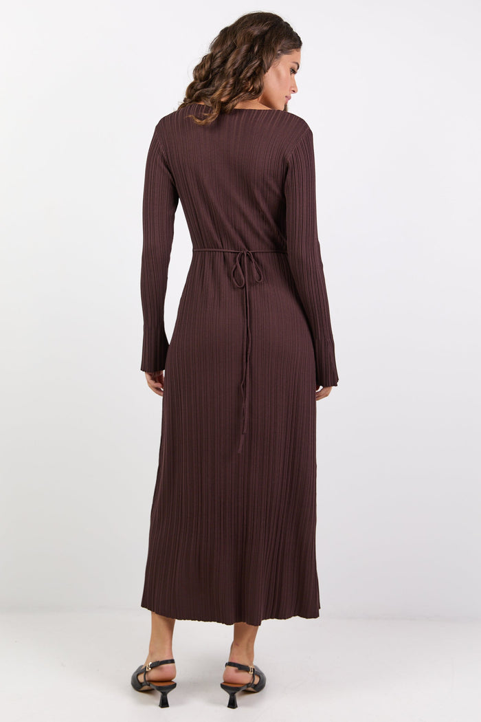 Woman wearing a long brown dress on a white background