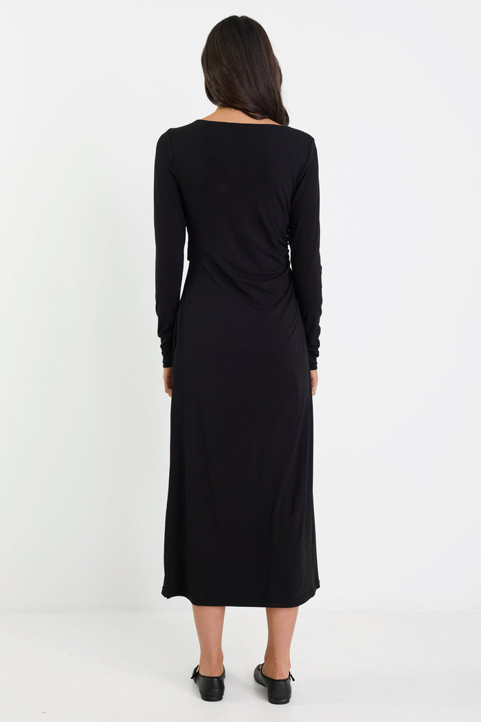 Woman wearing a black long-sleeve dress on a white background