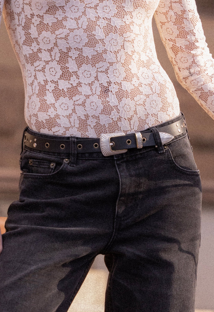 Spell Delphine Belt in Midnight black leather with ornate silver western buckle, studs and eyelets, styled with jeans