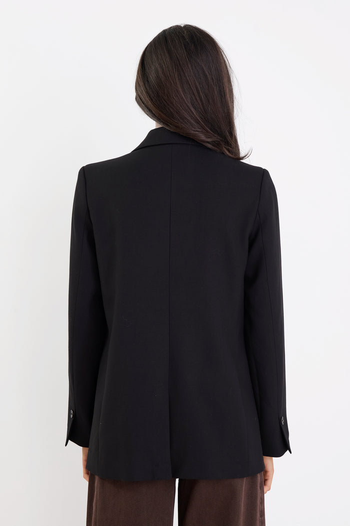 Person wearing a black blazer from behind on a white background
col_pattern