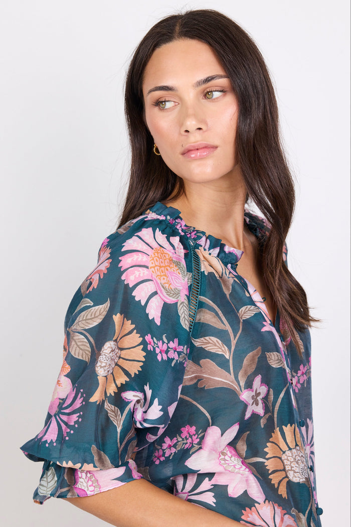 Woman wearing a floral blouse against a white background