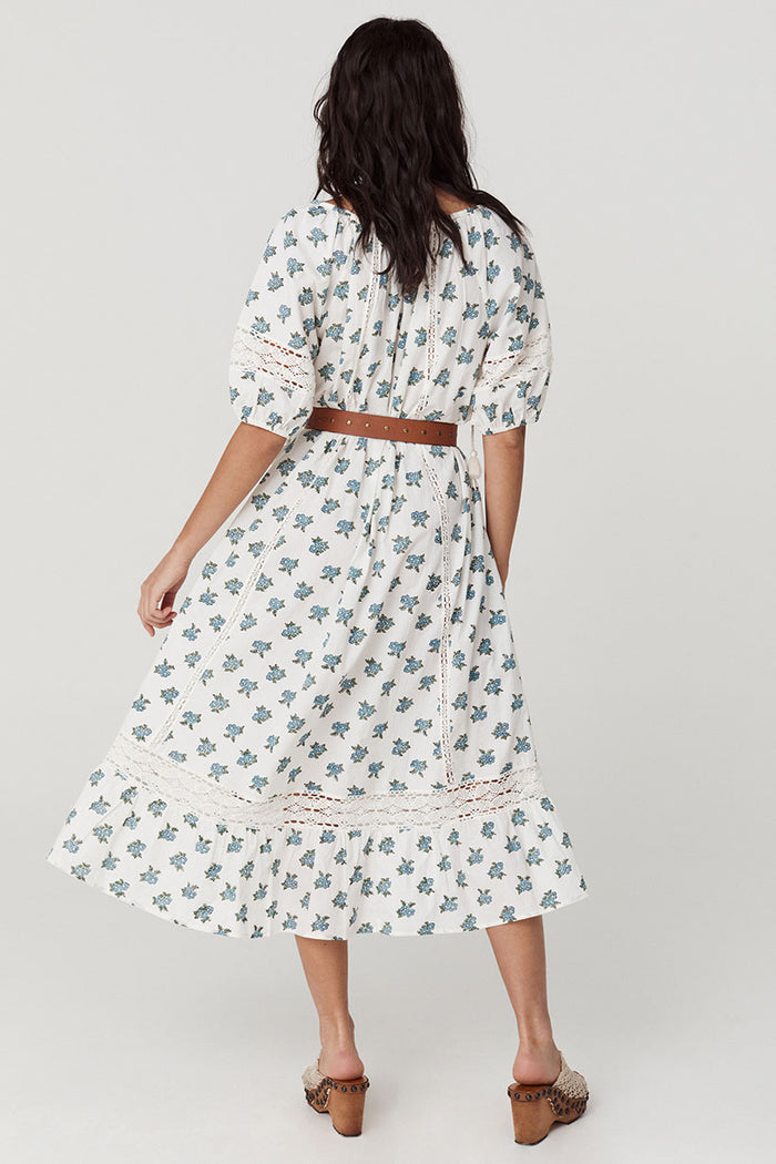 Back view showing lace inserts, centre-back seam, lace hem trim, and ruffle on Wild Poppy block print midi dress