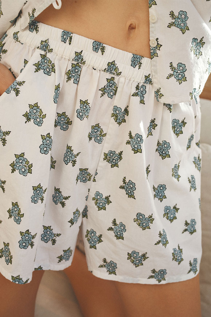 Close-up of floral block-printed shorts waistband with smocked elastic, white fabric with blue flower clusters
