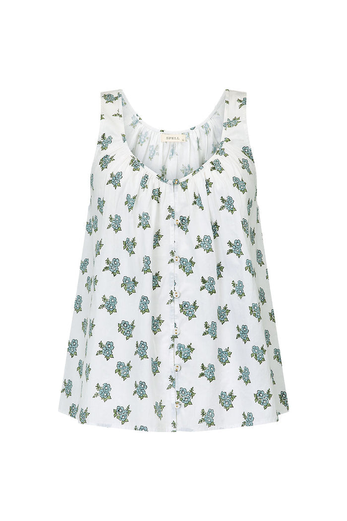 Flat lay of white sleeveless top with blue floral block print, gathered neckline, and button-front placket