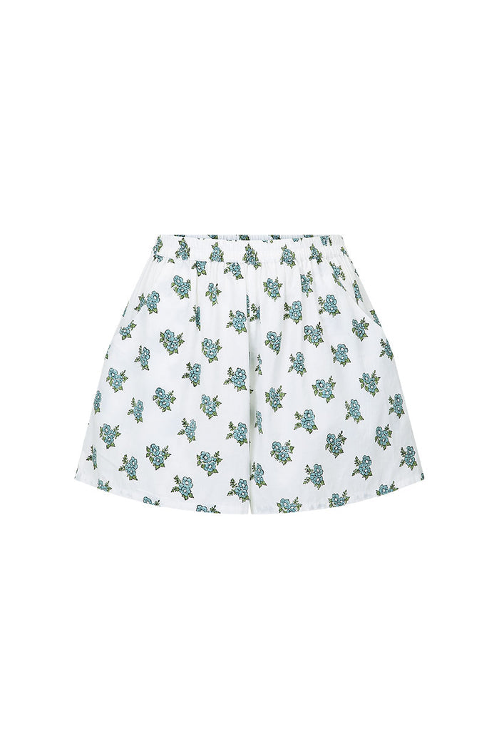 White block-printed lounge shorts with blue floral clusters and elastic waist, flat lay on white background