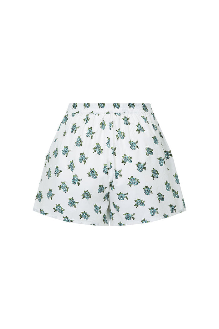 Flat lay of white lounge shorts with scattered blue floral print and elasticated waist from the Fable Lounge Set