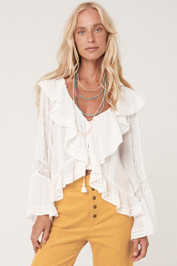 Front view of white Fleur Lace Frill Blouse showing V-neck, tassel ties, waterfall frill and lace sleeve inserts