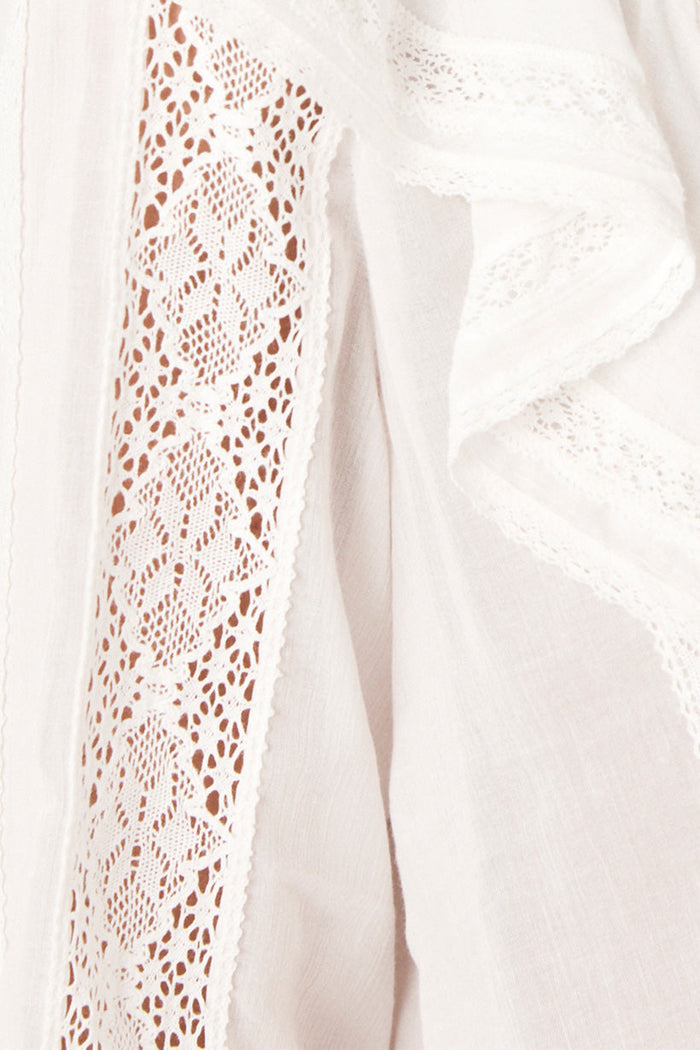 Close-up of diamond crochet lace insert panel and flutter frill detail on white blouse sleeve