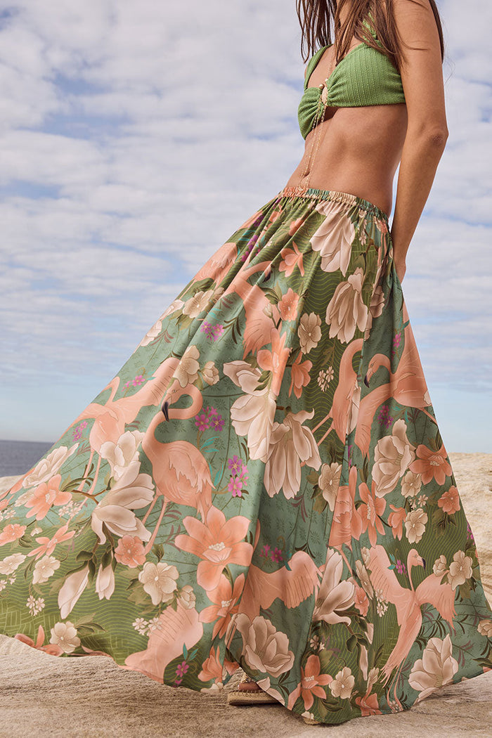 Front-angled view of flamingo floral print maxi skirt in sage, showing elastic waist and full flared length