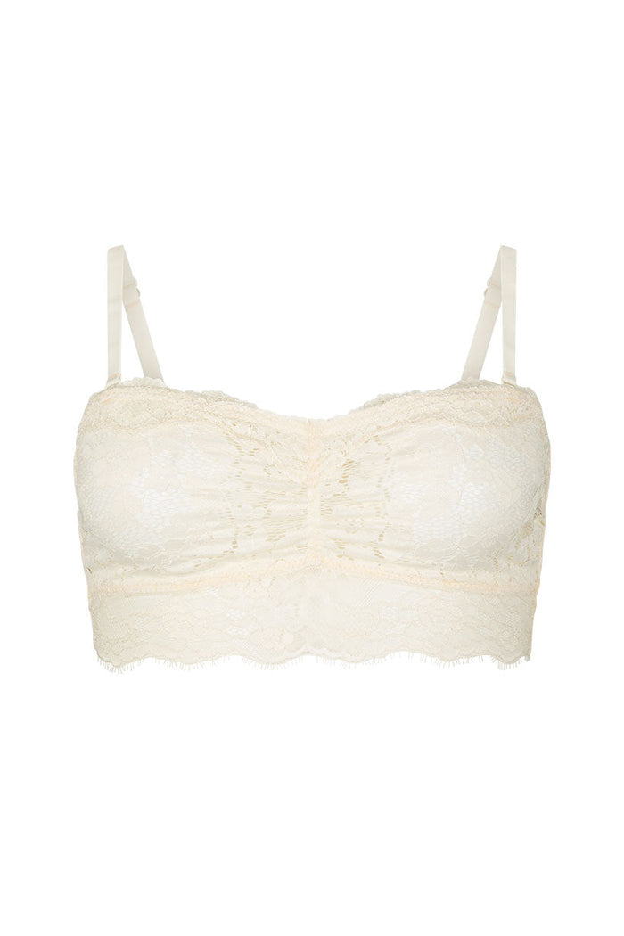 Cream lace bralette flat lay showing scalloped trim, ruched front, adjustable straps, and floral lace detail
