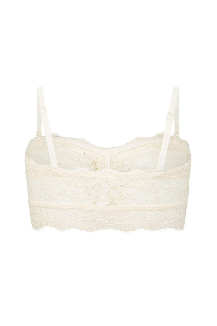 Cream lace bralette flat lay, back view, showing adjustable straps and scalloped lace trim hem