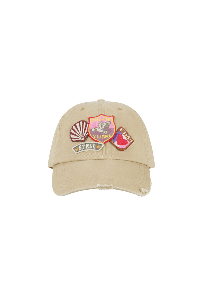 A beige distressed baseball cap featuring three colorful embroidered patches on the front, set against a plain white background.