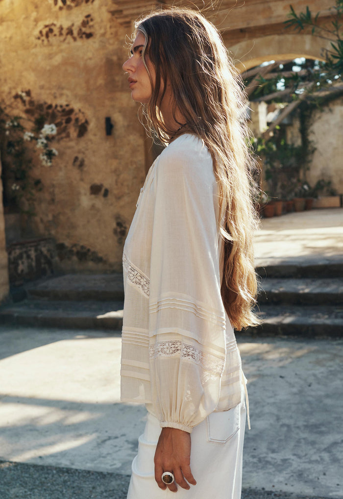 Model wearing Hera Lace Blouse side view, showing pintuck sleeve detail, lace trim insert and elastic cuff