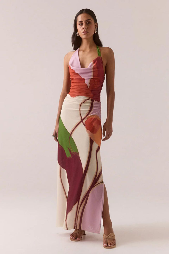 Woman wearing a colorful floral dress on a plain background