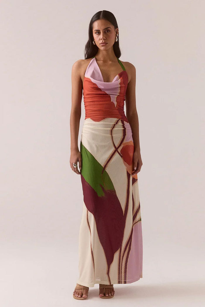 Woman wearing a colorful dress with abstract patterns on a plain background