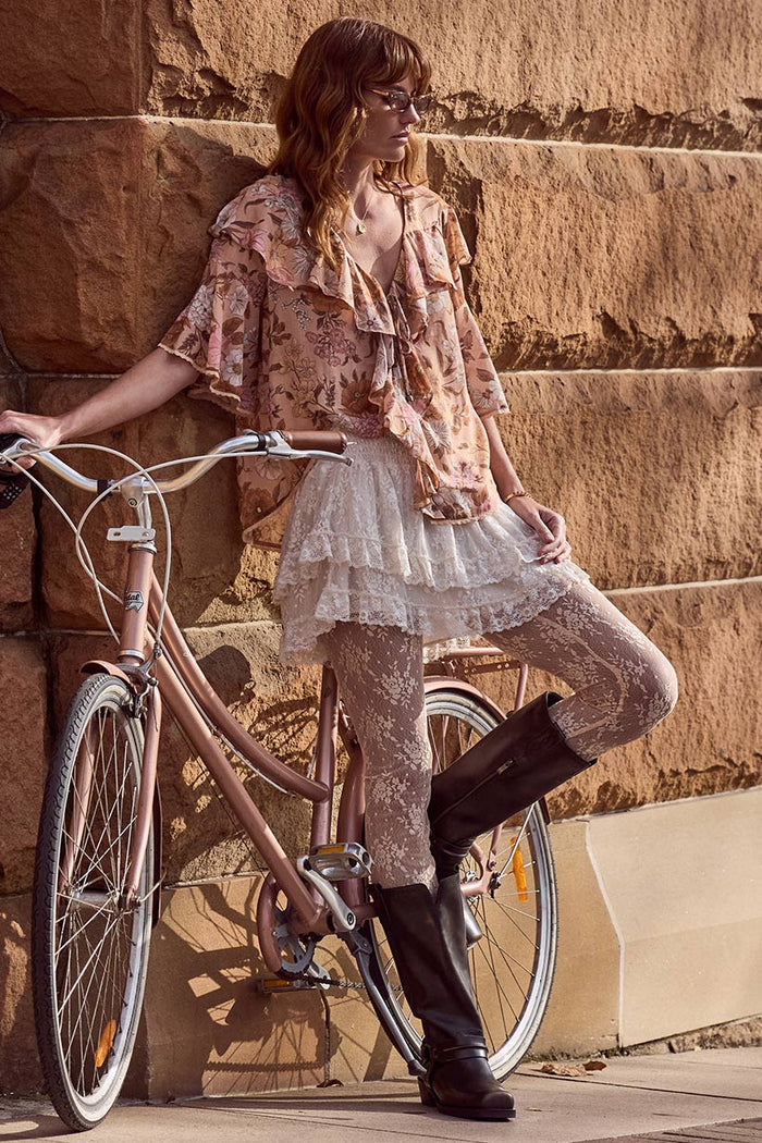 Side view of a model in Labyrinth Lace Mini Skirt, showing layered lace hem and shirred waist