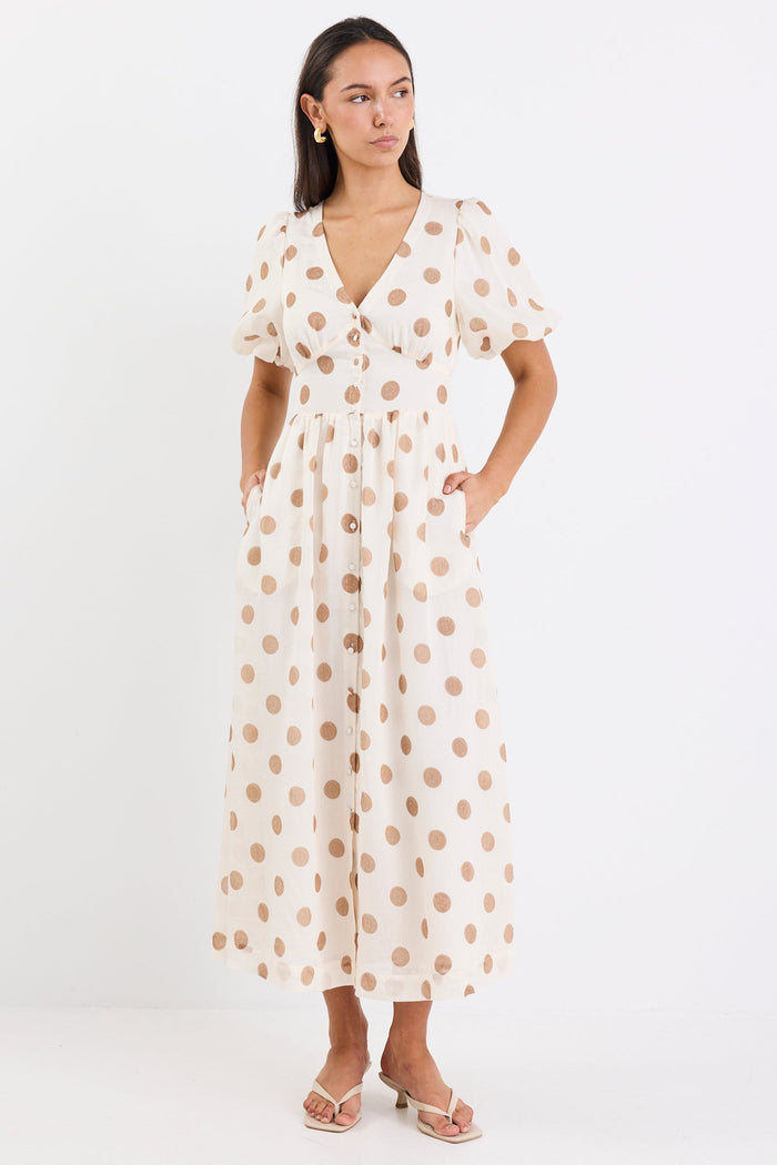 Woman wearing a cream brown polka dot maxi dress