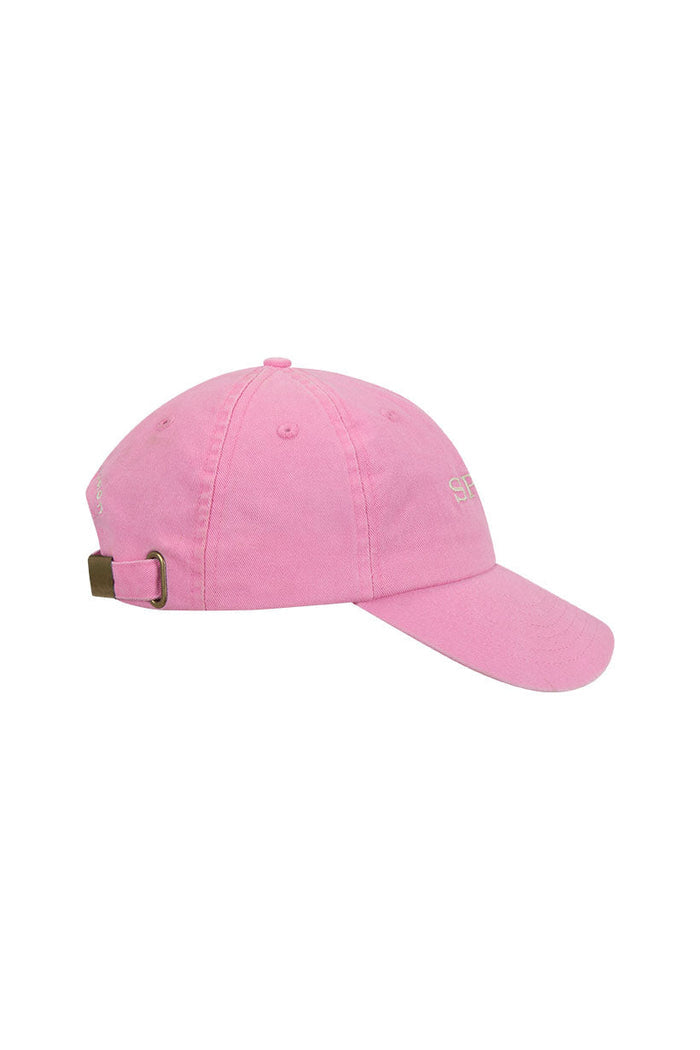 Side view of bubblegum pink organic cotton kids' cap showing embroidered Spell logo and brass adjustable back band