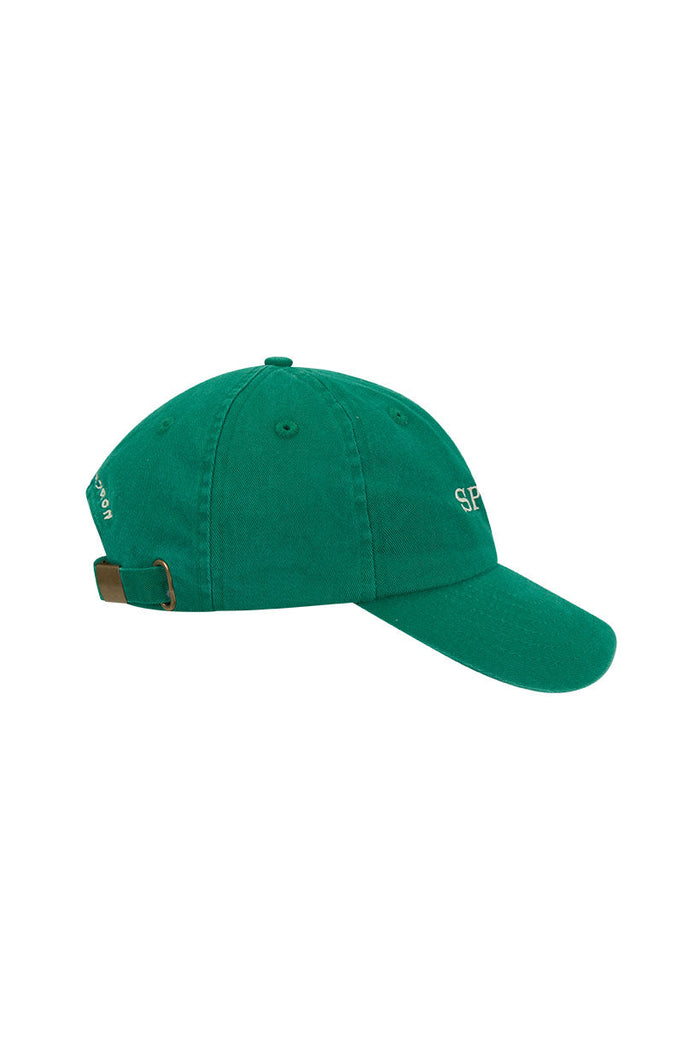 Side view of green organic cotton kids' cap showing embroidered logo and adjustable back band closure