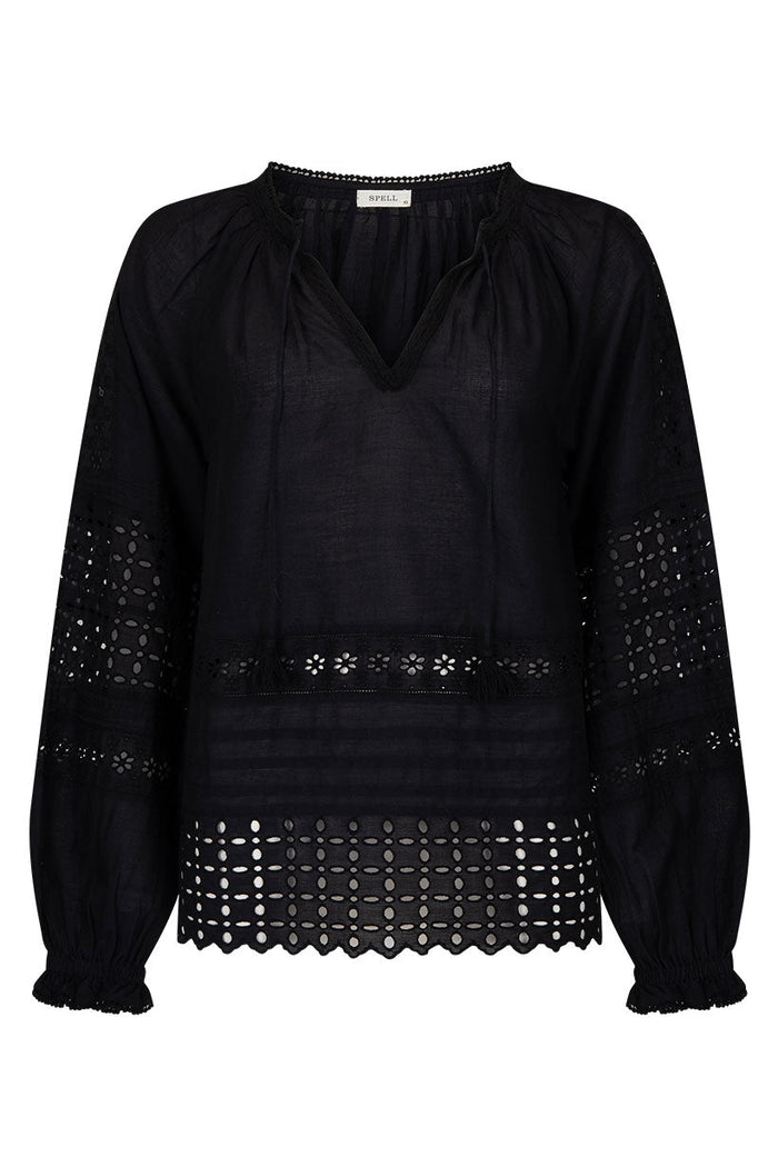 Black blouse flat lay showing schiffli anglaise hem, blouson sleeves, elasticated cuffs, and front tie with tassels