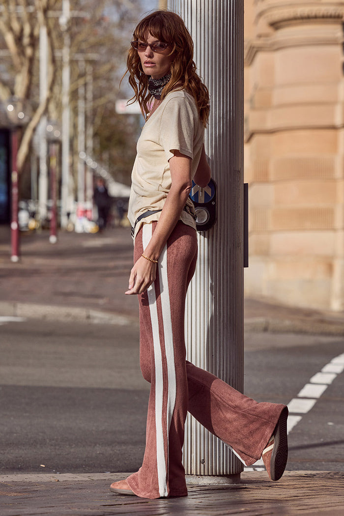 Model side profile in Luciana Terry Flares, chocolate viscose with cream contrast stripe and flared leg