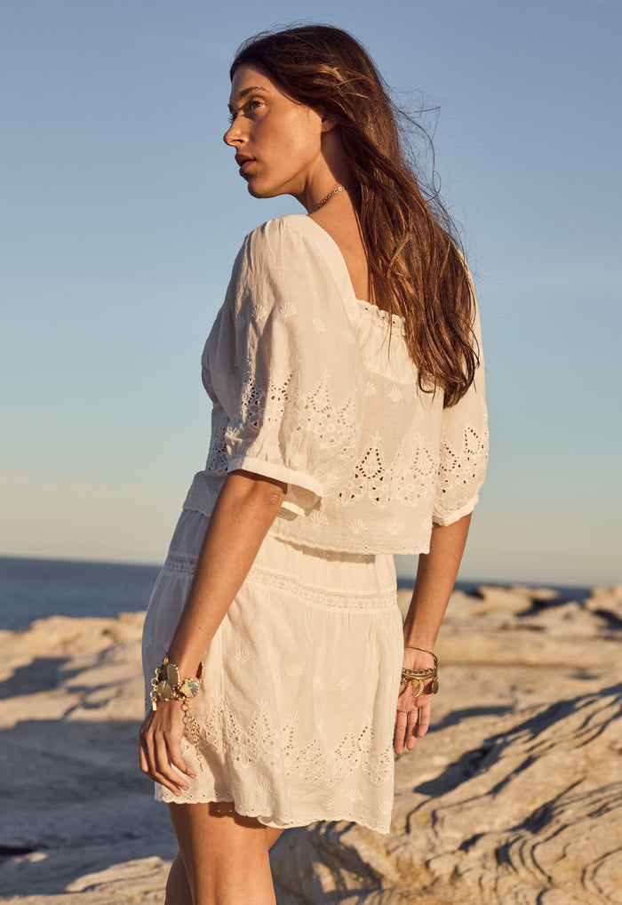 Side view of Maiden Lace Blouse in antique white, showing custom anglaise detailing and elbow-length sleeves on model