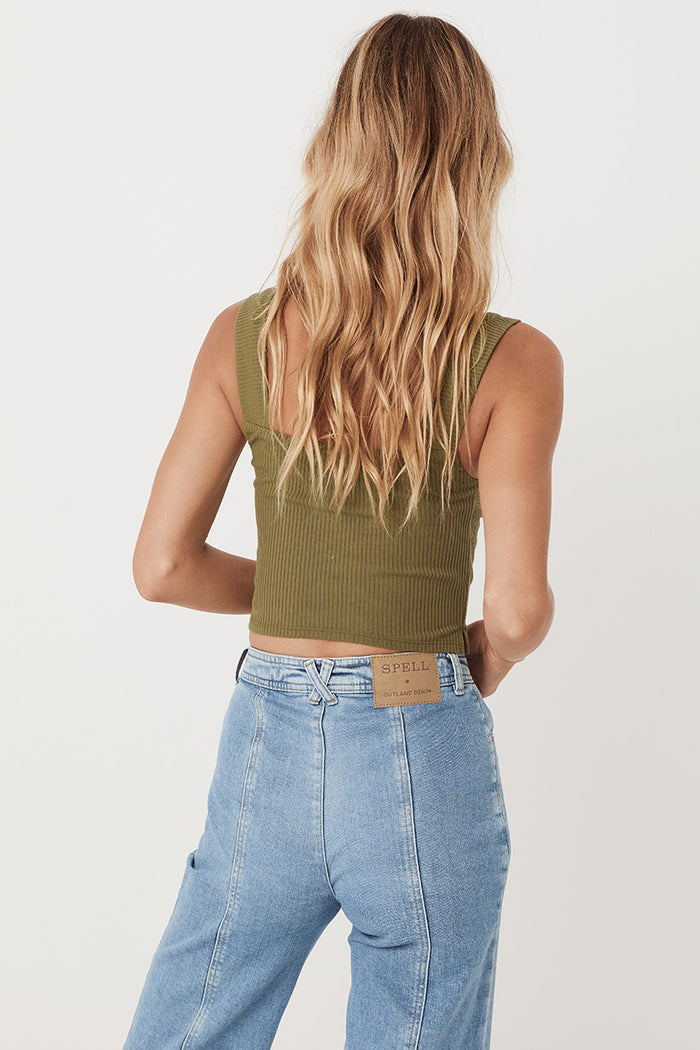 An image of studio model, Lea Mohr, wearing the Mazzy Ribbed Top. The top comes in a khaki colourway and features a square neckline and thick straps.