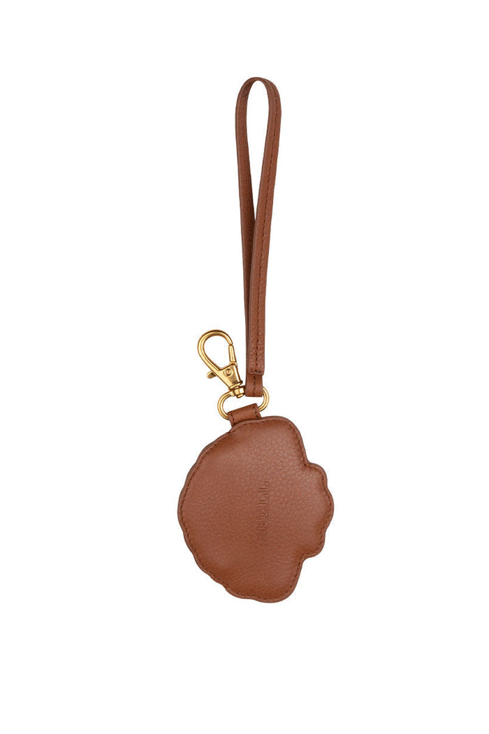 Back view of tan deadstock leather shell coin purse with gold lobster clasp and wrist strap, white background