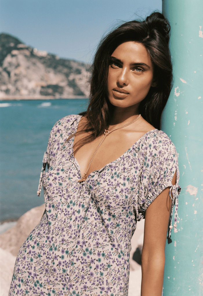 Model wearing Mimi-Rose Mini Dress front view, gathered neckline and elastic tie sleeves in violet floral print