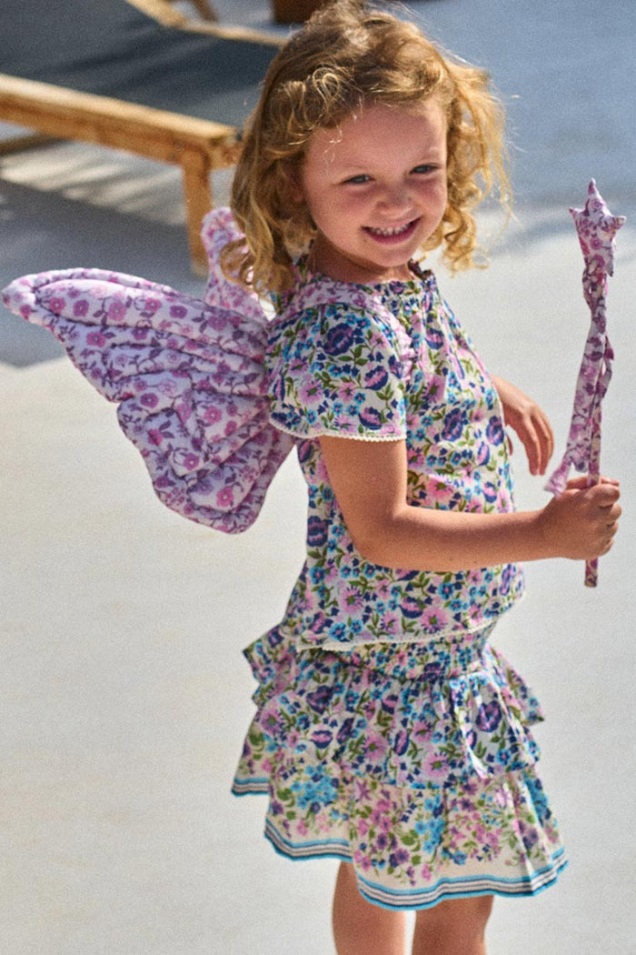 Child wearing floral print fairy wings and holding matching star wand in lilac floral fabric