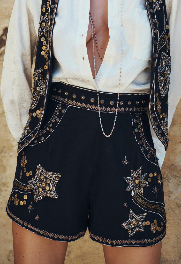 Close-up of star and sequin embellishments on high-waisted midnight shorts with embellished waist trim