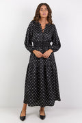 Woman wearing a black dress with white patterns on a white background