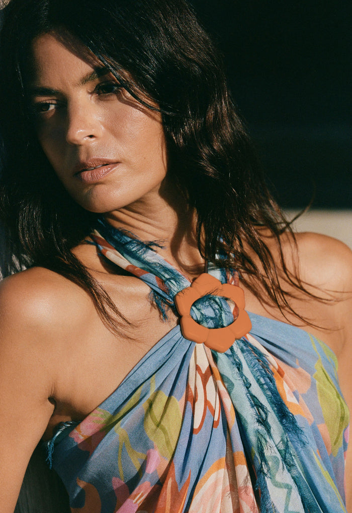Close-up of terracotta flower buckle detail on Sea Blue Modal scarf with frayed edges and multicolour print