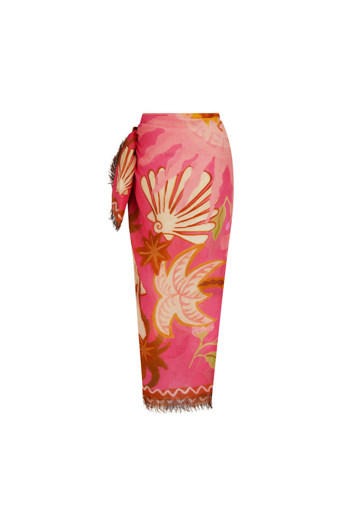 Oceana Travel Scarf in Coral tied as sarong, pink modal with shell print, frayed hem, ric-rac border, white background