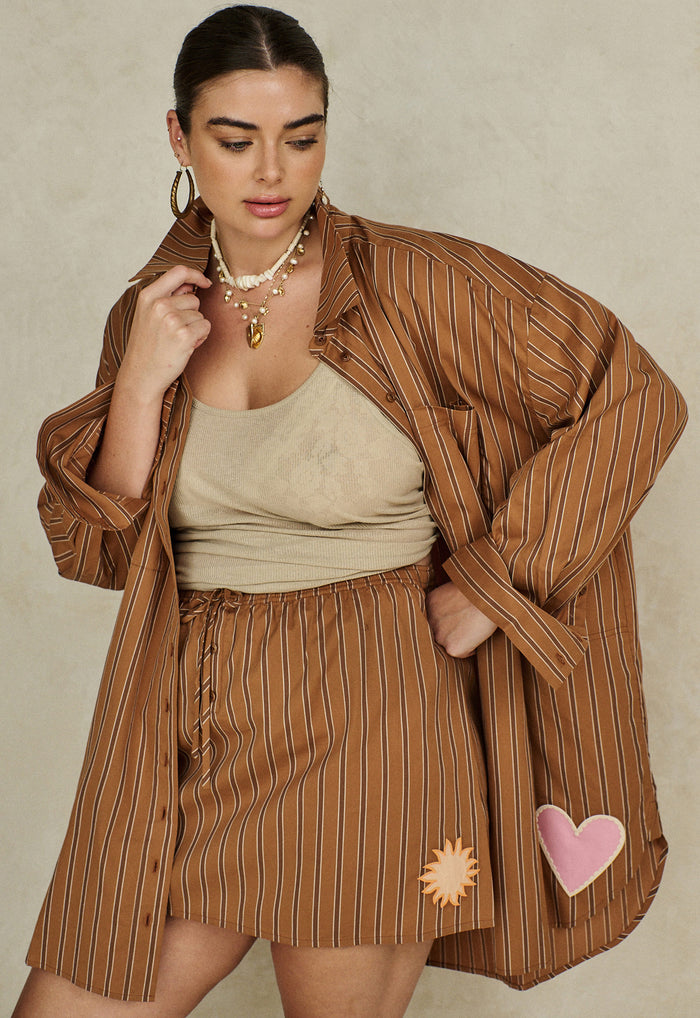 Caramel stripe organic cotton oversized shirt, flat lay front view showing applique pocket and hem detail
