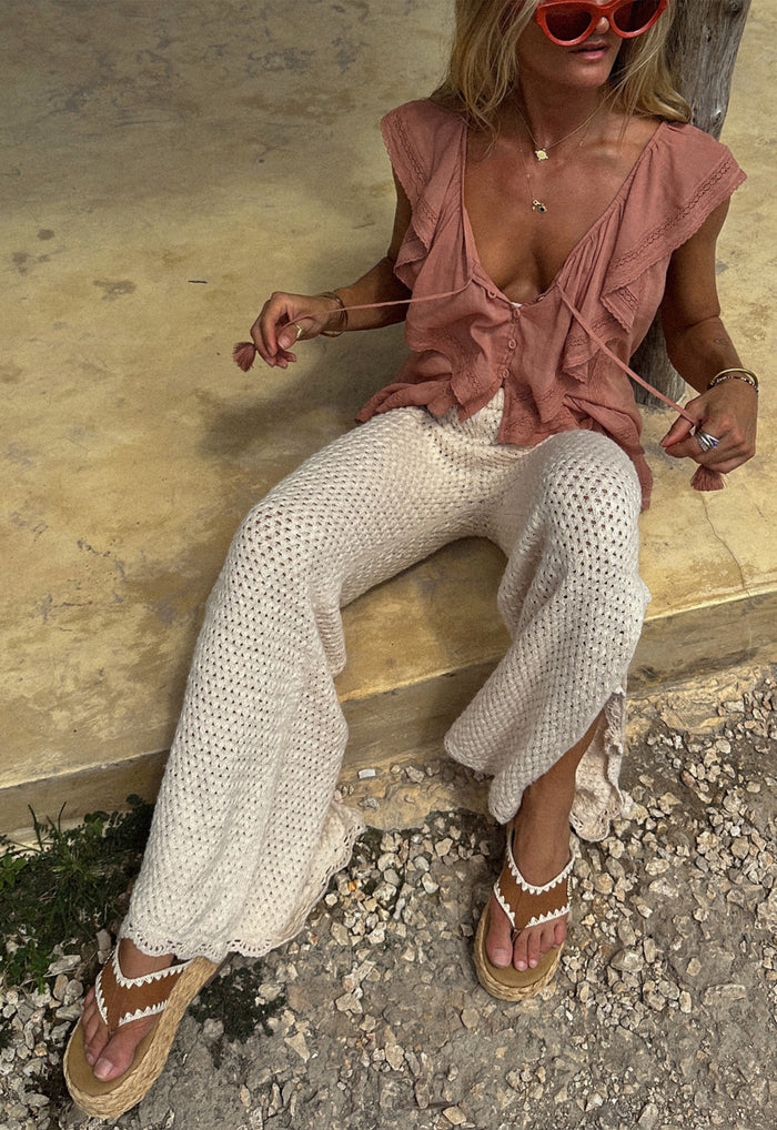 Cream knit Paradise Found Pant laid flat showing scallop hem edge and open-stitch texture, front view