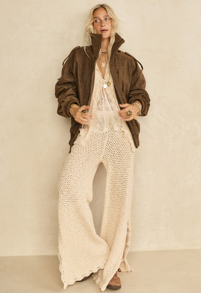 Spell women's Paradise Found Pant in Sand Dune cream knit wide-leg with scallop hem, styled with brown jacket