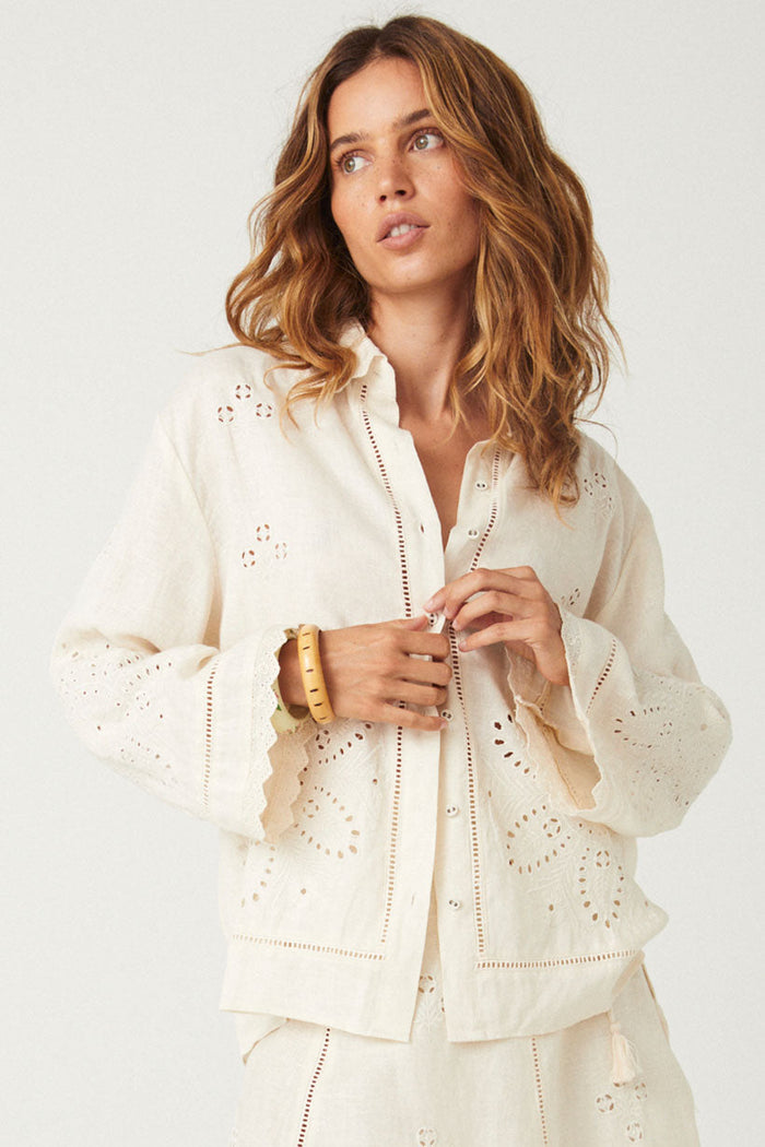 Front view of eyelet embroidery shirt in antique creme with scallop lace cuffs and button placket