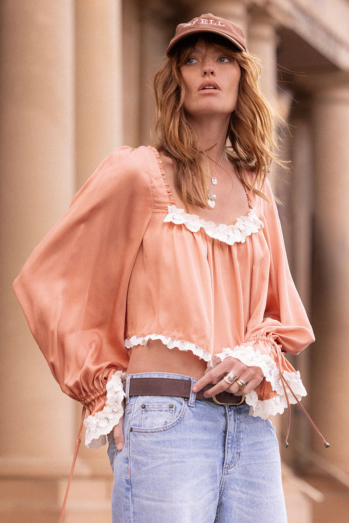 Rose blouse front view showing lace-trim neckline, cropped hem, and bishop sleeves with tie cuffs