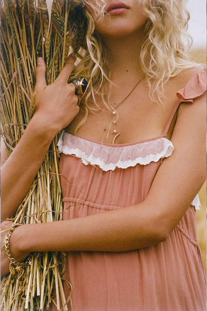 Close-up of lace-trimmed neckline frill and adjustable straps on rose mini dress, styled with gold jewellery